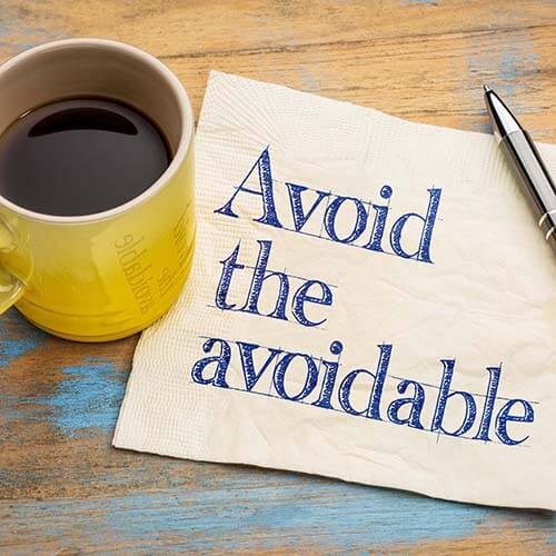 Coffee cup and napkin with words avoid the avoidable