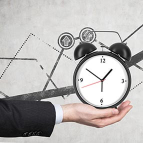 Hand holding a clock signifying time for strategic planning for business owners