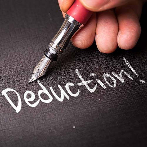 Tax deduction written in white ink on black paper representing the qualified business income tax deduction