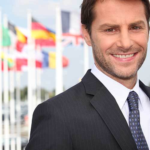 smiling man in front of international flags