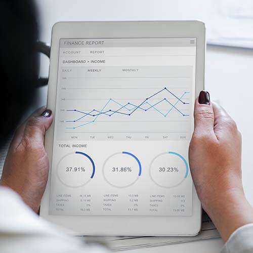 Woman holding iPad showing financial charts