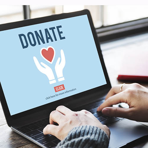 Woman typing on computer with a donation site