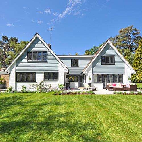 house with green lawn and blue sky