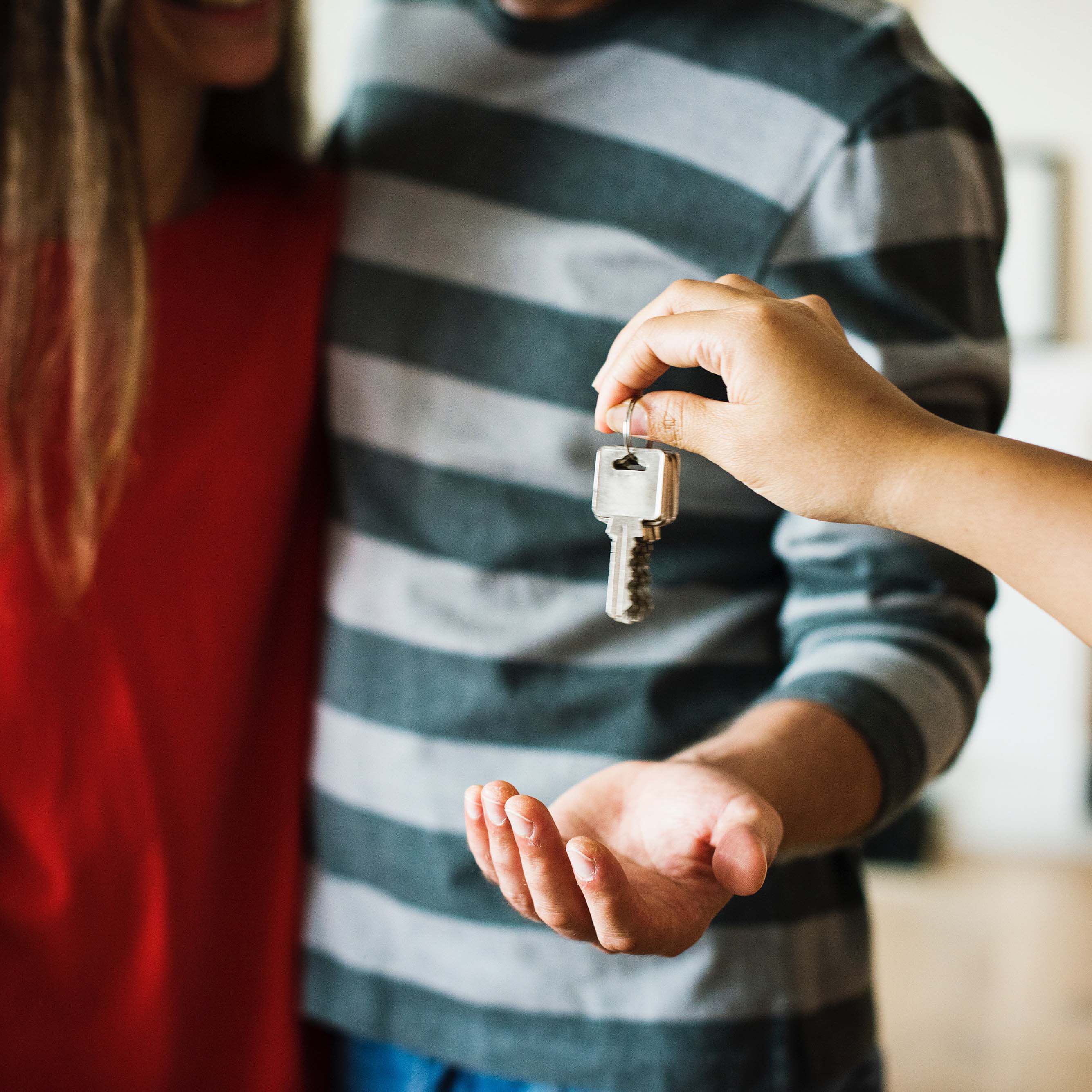 house keys being handed to a couple