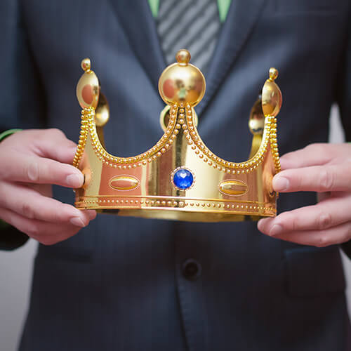 Businessman king holding in hands a gold crown.