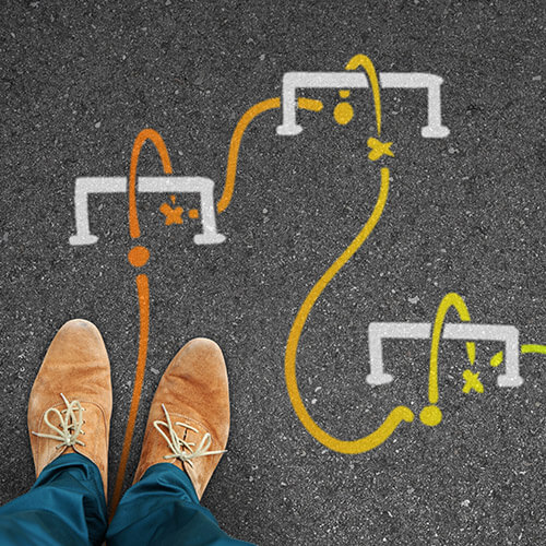 man standing on road with three hurdles