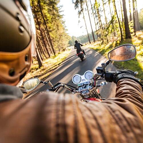 Man seat on the motorcycle on the forest road.