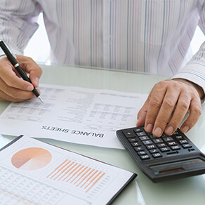 Man working on financial statement using calculator