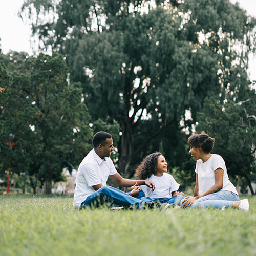 young family sitting on grass