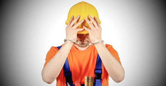 failure guilty laborer regretful criminal handcuffed hard hat blue collar portrait on white background