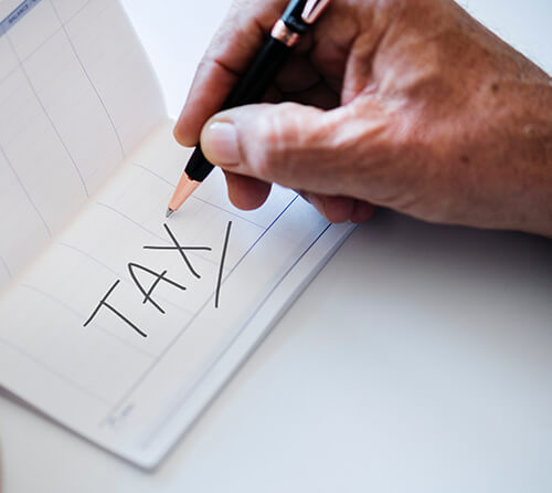 man writing tax on checkbook