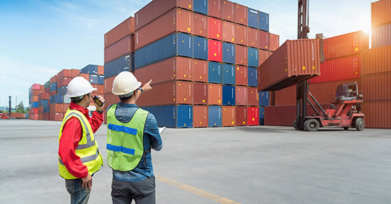 Men looking at boxes of international trade goods